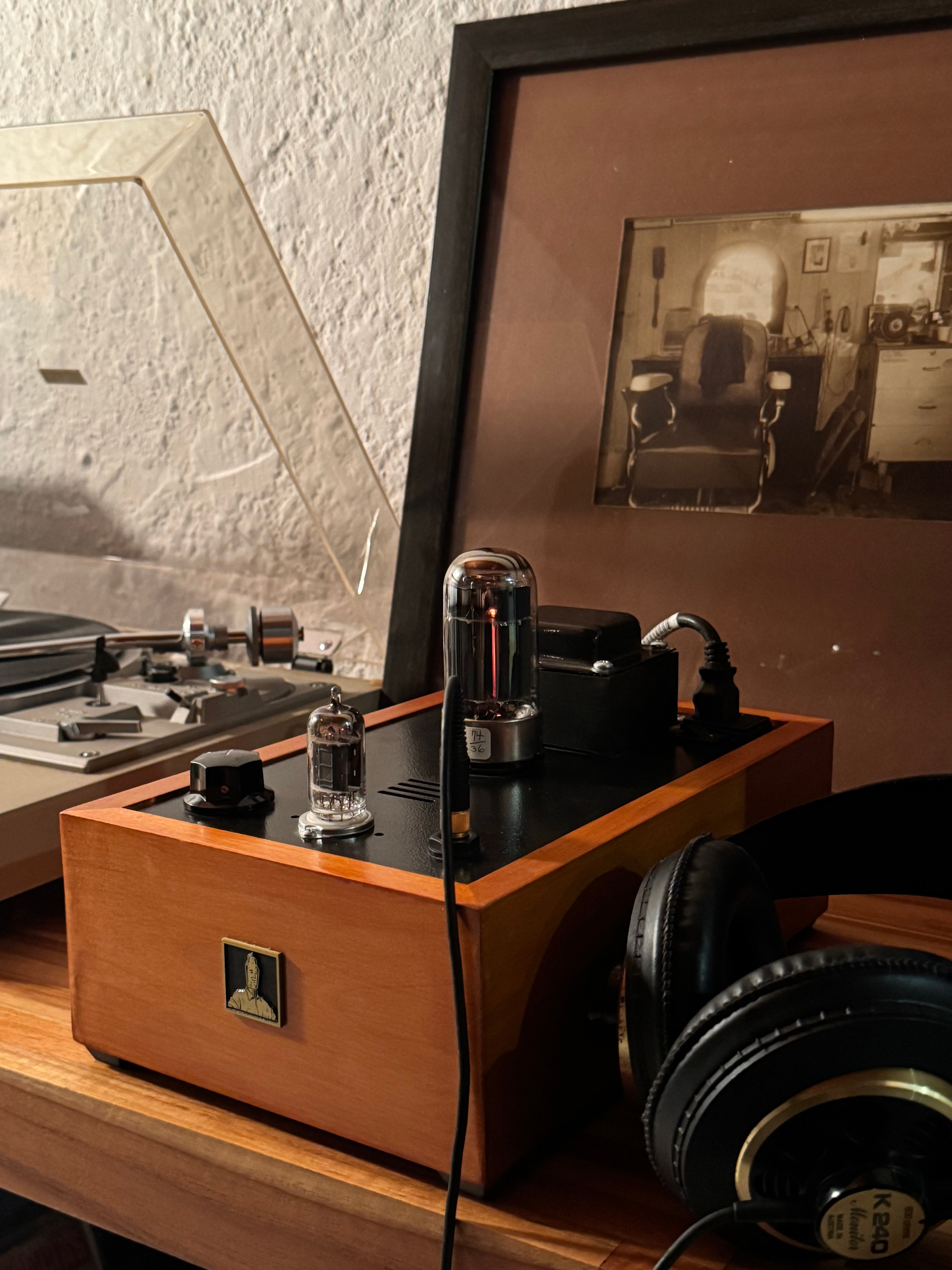 Bottlehead Crack and record player with headphones and a framed photo on a wooden surface.