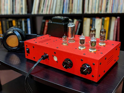 Bottlehead Stat Electrostatic Headphone Energizer in red with a pair of electrostatic headphones.